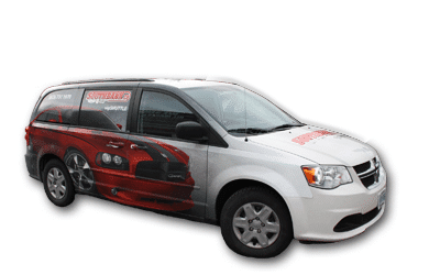 Fourgonnette blanche avec des graphiques personnalisés et l'image d'une voiture de sport rouge sur le côté.