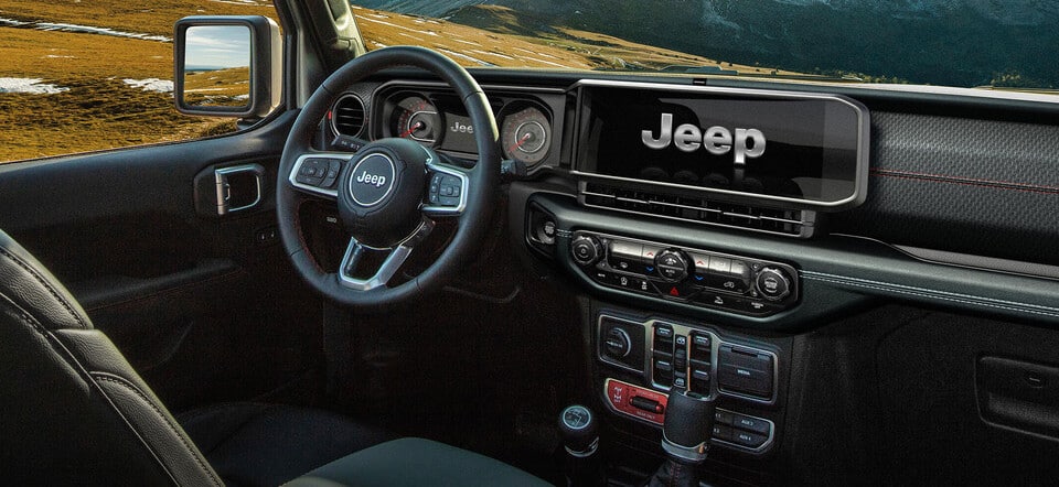 Intérieur du tableau de bord Jeep avec volant et affichage numérique dans un décor paysager.