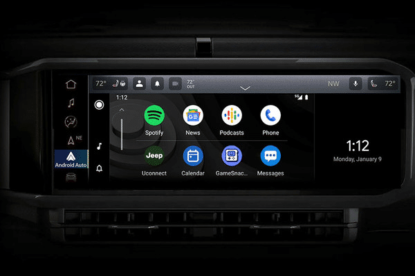 Car dashboard display with apps including Spotify, News, Podcasts, and phone. Time shown is 1:12.