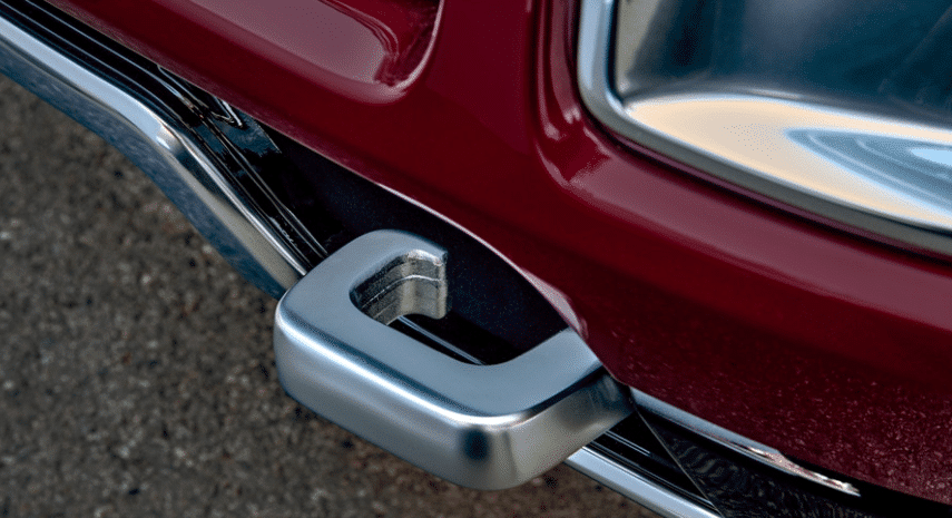 Car tow hook attached to a red vehicle bumper, highlighting automotive design and safety features.