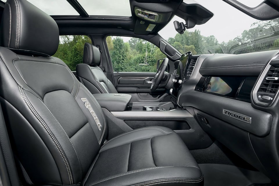 Luxurious truck interior with black leather seats, sunroof, and digital dashboard display.