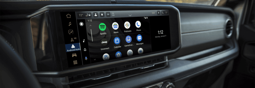 Car dashboard screen with apps like Spotify, Podcasts, Messages, and Android Auto displayed.