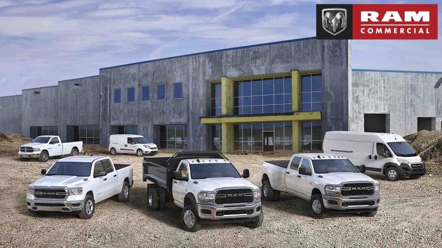 RAM trucks and vans parked outside a commercial building, showcasing fleet options.