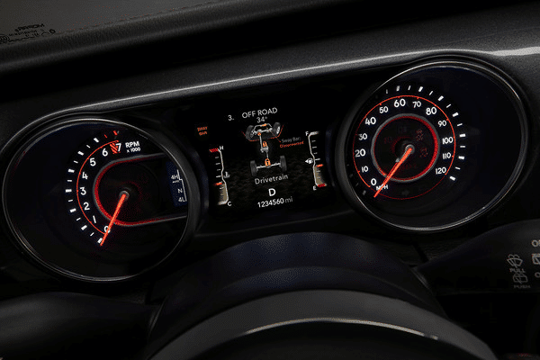 Car dashboard with illuminated speedometer, tachometer, and off-road mode display showing drivetrain data.